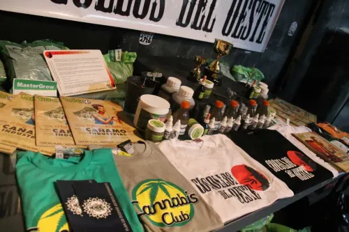 Mesa de un stand con revistas cannábicas, productos de cultivo, copas y remeras, Copa Cata del Oeste 2015