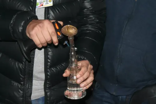 Manos con un soplete y una pipa de agua de vidrio para extractos, Copa Cata del Oeste 2015