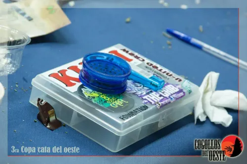 Picador azul y encendedor sobre una caja con calcos de marcas cannábicas, Copa Cata del Oeste 2016