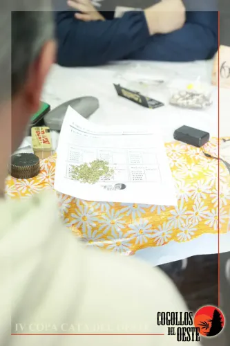 Ficha de cata con flor picada sobre la mesa 6, entre papelillos y un picador, Copa Cata del Oeste 2017