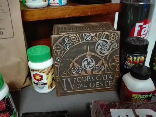 Caja tallada con engranajes de la Copa entre fertilizantes de varias marcas, Copa Cata del Oeste 2017