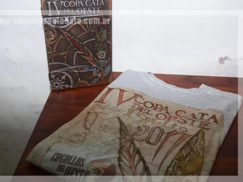 Remera de la Copa doblada junto a la caja tallada de premio, Copa Cata del Oeste 2017