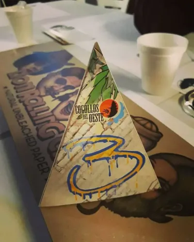 Cartel triangular de la mesa 3 apoyado sobre un paquete grande de papelillos ilustrados, Copa Cata del Oeste 2018