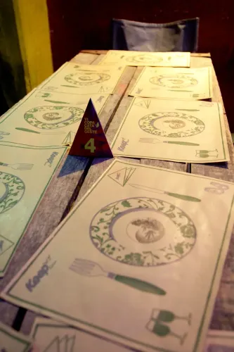 Mesa con individuales de papel ilustrados y el cartel triangular de la mesa 4, Copa Cata del Oeste 2019