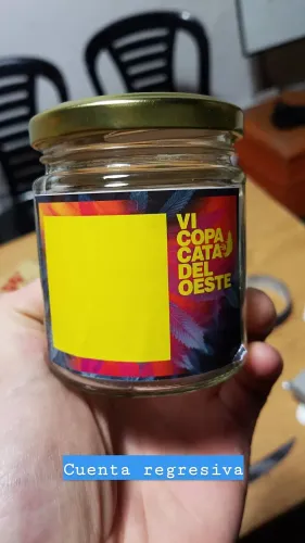Una mano sostiene un frasco de muestra vacío con la etiqueta de la Copa, Copa Cata del Oeste 2019