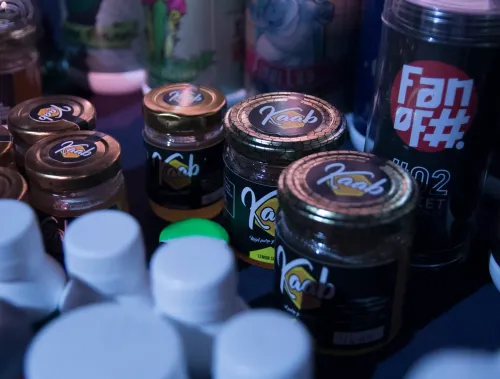 Frascos de miel de una marca y tubos de otra, detrás de tapas blancas desenfocadas, Copa Cata del Oeste 2019