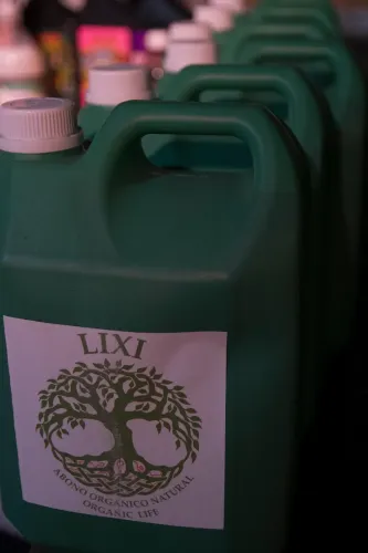 Fila de bidones verdes de abono orgánico con la etiqueta de un árbol, Copa Cata del Oeste 2019