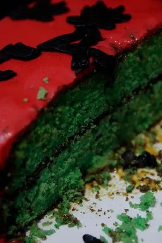 Porción de torta con bizcochuelo verde y cobertura roja decorada con hojas negras, Copa Cata del Oeste 2019