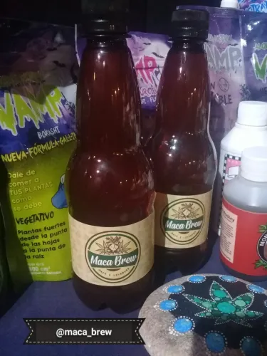Botellas de una bebida de maca entre bolsas de abono y una piedra pintada, Copa Cata del Oeste 2019