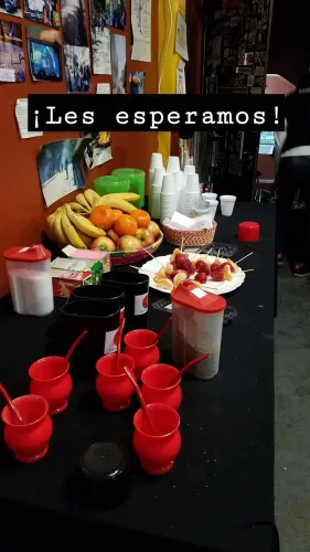 Mesa de bienvenida con mates rojos, frutas, brochetas de frutilla y vasos, Copa Cata del Oeste 2019