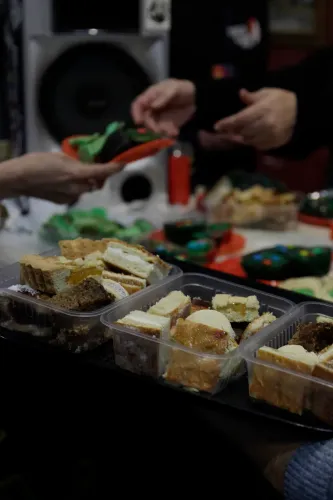 Bandejas con porciones de budín y manos que se pasan un plato con galletitas verdes, Copa Cata del Oeste 2019