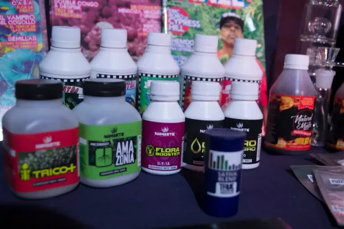 Botellas de fertilizantes y un frasco de terpenos ante tapas de revistas cannábicas, Copa Cata del Oeste 2019