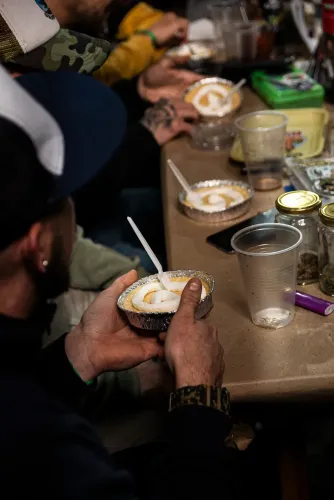 Una persona de espaldas sostiene una tarta con merengue en la mesa de cata, Copa Cata del Oeste 2022