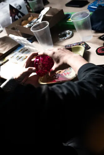 Manos abren un picador fucsia sobre una bandeja con flor picada, Copa Cata del Oeste 2022