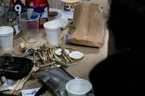 Mesa con colillas de porros, vasos de telgopor y una bandeja con flores, Copa Cata del Oeste 2022