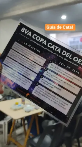 Una mano sostiene la guía de cata plastificada con los pasos para catar, Copa Cata del Oeste 2022