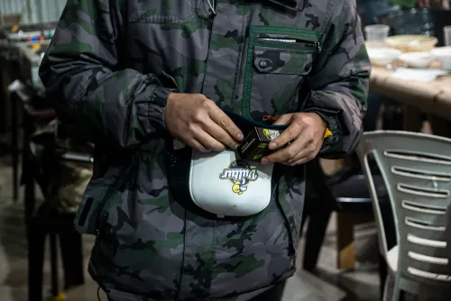 Una persona sostiene una gorra con el logo de un banco de semillas, Copa Cata del Oeste 2022