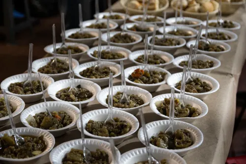 Platos de telgopor con guiso y cucharas en fila sobre la mesa del almuerzo, Copa Cata del Oeste 2022
