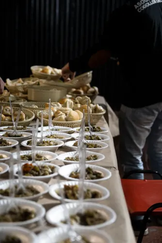 Mesa larga con platos de guiso y canastas de pan listos para el almuerzo, Copa Cata del Oeste 2022