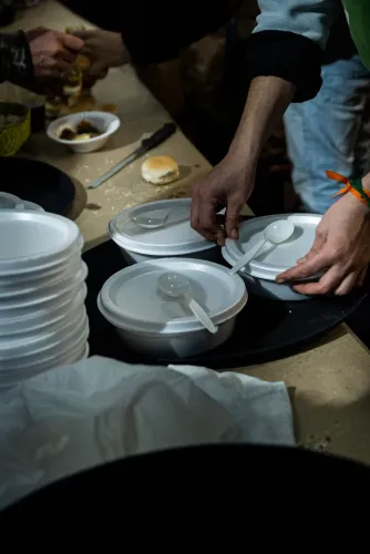 Manos acomodan viandas de telgopor con cucharas sobre una bandeja para el almuerzo, Copa Cata del Oeste 2022