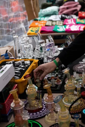 Pipas y piezas de vidrio para extractos en la mesa de un stand, Copa Cata del Oeste 2022
